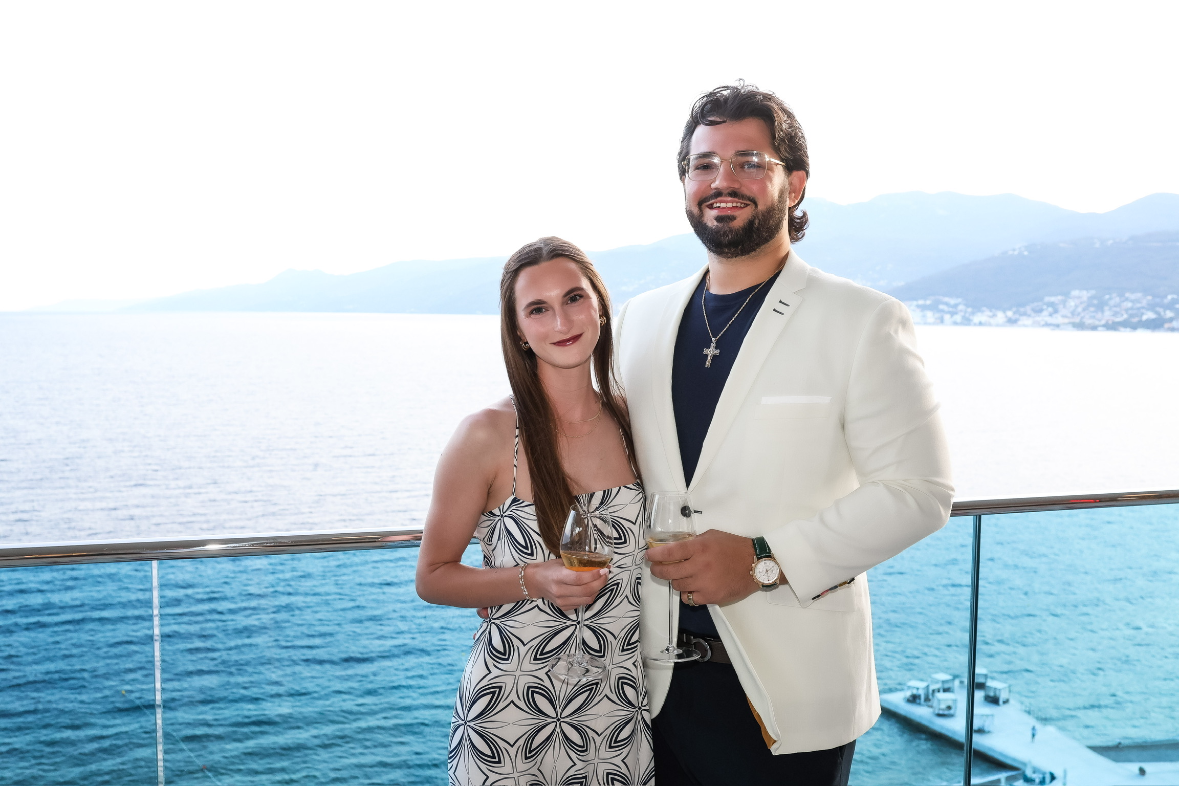 Tatum and Zachary raising glasses together with the lake behind them